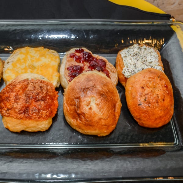 A tray of vegan baked goods, including cheese toast, peanut butter and jelly, and savory buns.